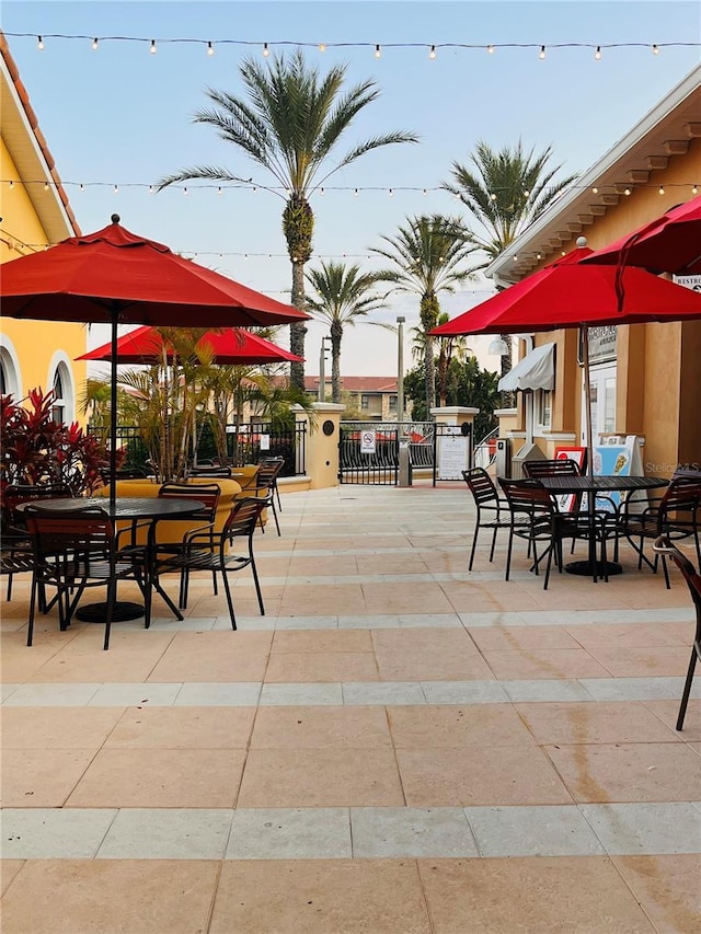 exterior space featuring a gate, fence, a patio, and outdoor dining space