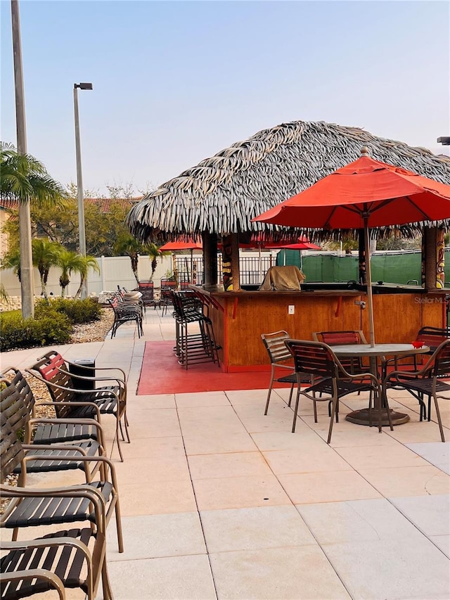 view of patio / terrace with outdoor dry bar, outdoor dining space, and fence