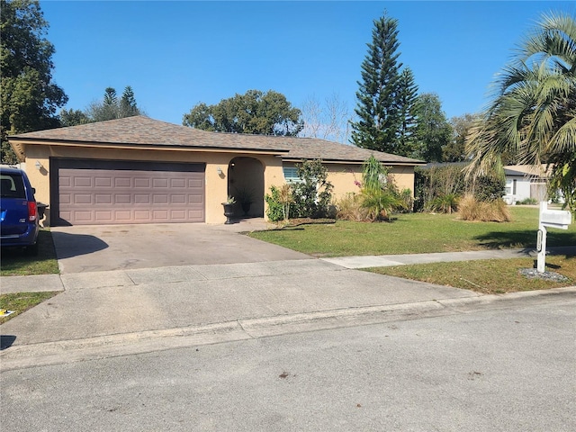 single story home featuring a garage, driveway, a front lawn, and stucco siding