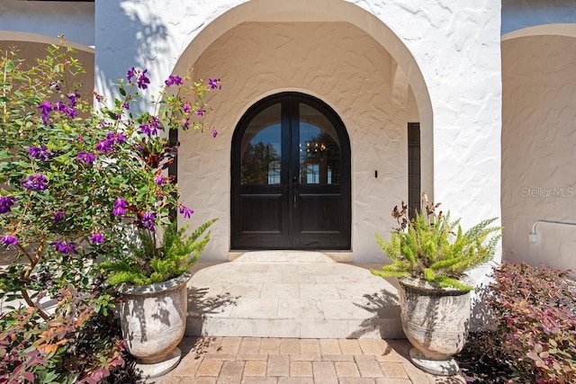 property entrance with french doors and stucco siding