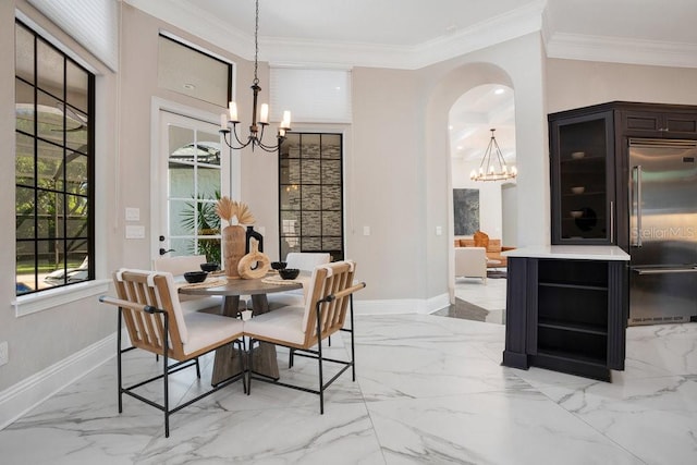 dining space featuring a notable chandelier, crown molding, and baseboards