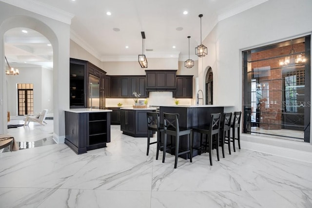 kitchen featuring stainless steel built in fridge, marble finish floor, a kitchen breakfast bar, arched walkways, and light countertops