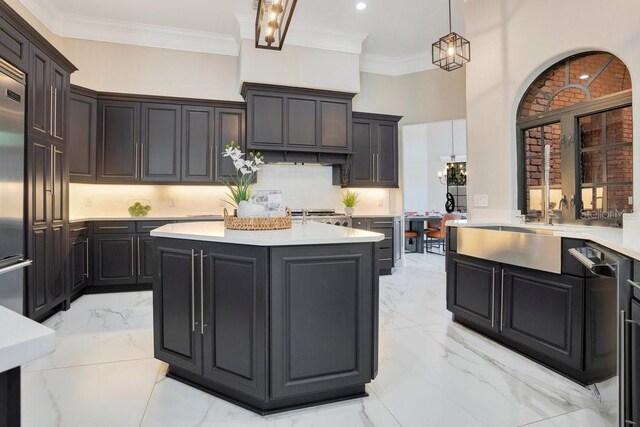 kitchen featuring a center island, marble finish floor, and ornamental molding