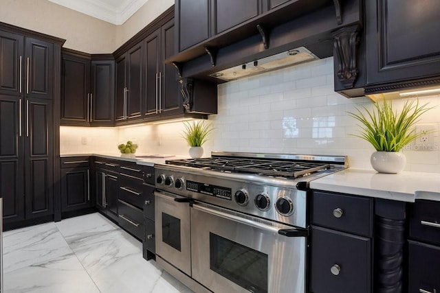 kitchen with marble finish floor, ornamental molding, under cabinet range hood, light countertops, and range with two ovens