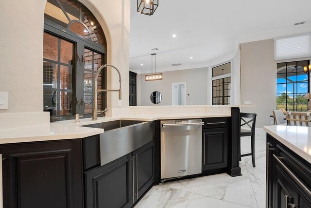 kitchen featuring dark cabinetry, ornamental molding, light countertops, stainless steel dishwasher, and marble finish floor