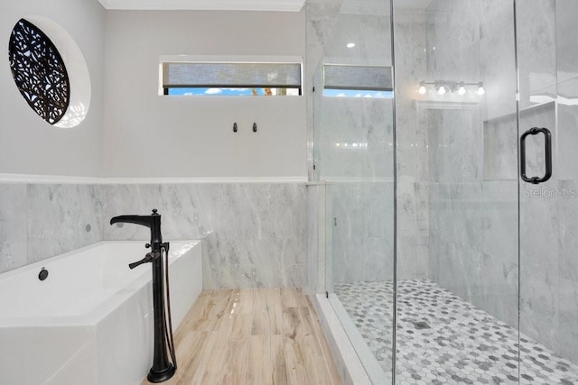 bathroom featuring a freestanding bath, tile walls, and a shower stall