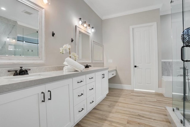 full bath featuring visible vents, double vanity, a stall shower, wood finished floors, and a sink