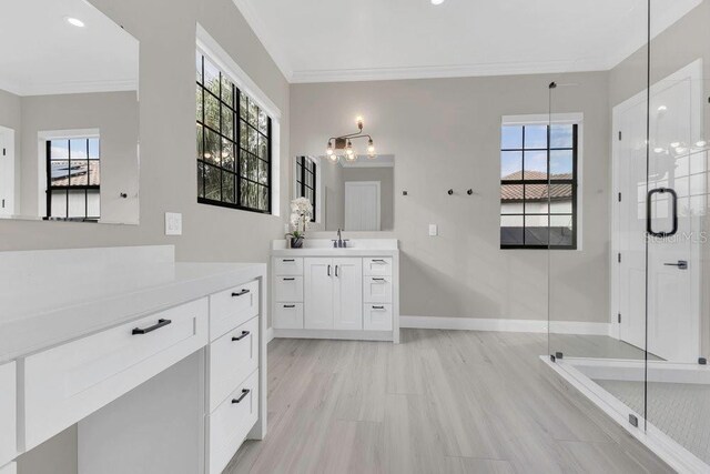 full bath with a stall shower, vanity, crown molding, and baseboards