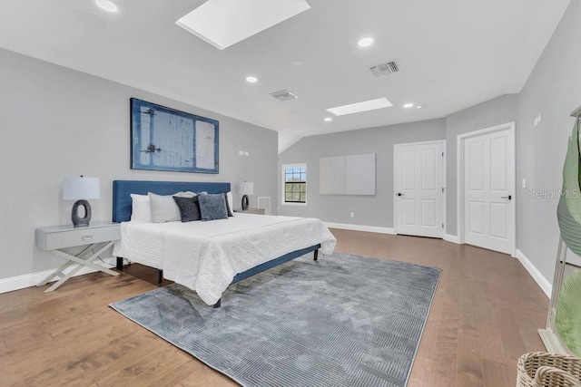 bedroom with wood finished floors, visible vents, and baseboards