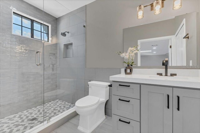 bathroom featuring vanity, toilet, tile walls, and a shower stall