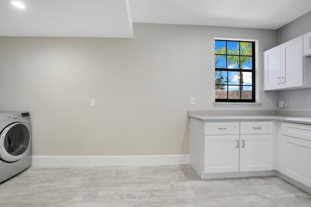 laundry area with cabinet space, washer / clothes dryer, light wood-type flooring, and baseboards