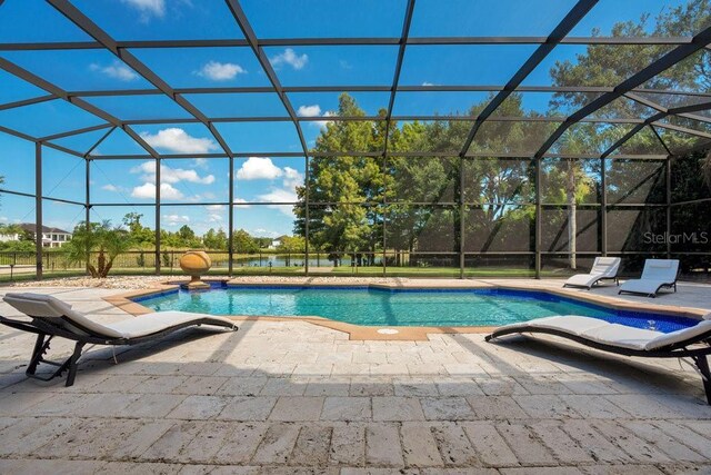 pool featuring glass enclosure and a patio