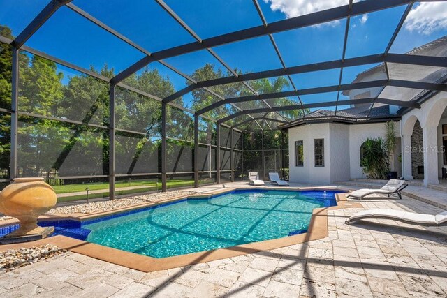 view of pool featuring glass enclosure, a patio area, and a fenced in pool