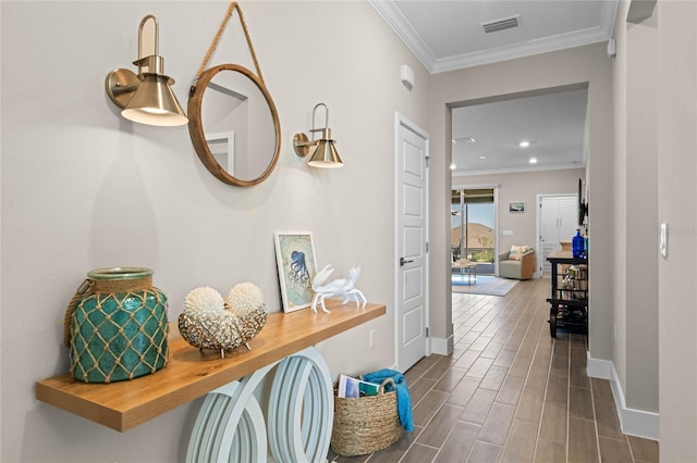 hall featuring crown molding, baseboards, visible vents, and wood tiled floor