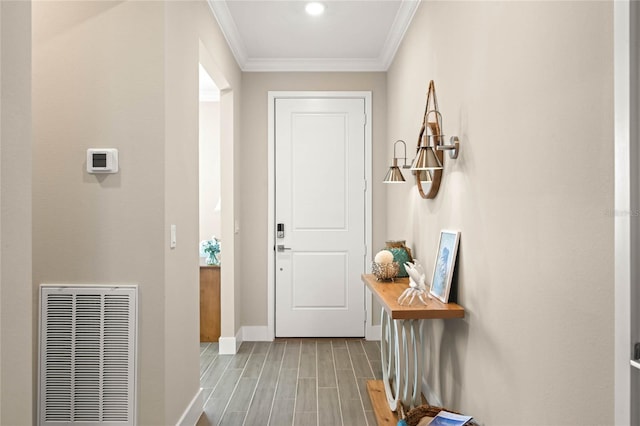 doorway to outside featuring visible vents, baseboards, light wood-style floors, and ornamental molding