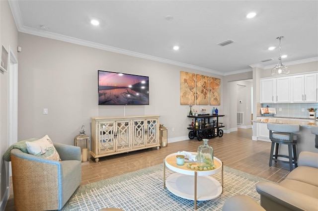 living area with wood finish floors, visible vents, and crown molding