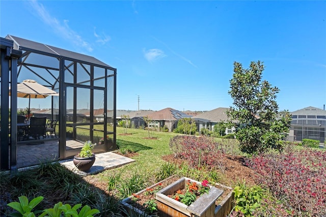 view of yard with glass enclosure and a vegetable garden