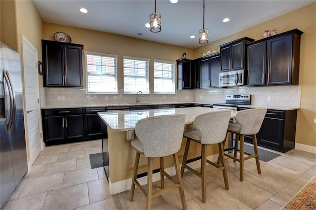 kitchen with a sink, stainless steel appliances, tasteful backsplash, and a kitchen island