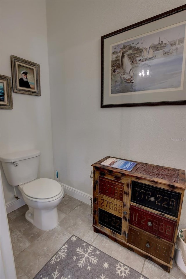 bathroom featuring baseboards and toilet