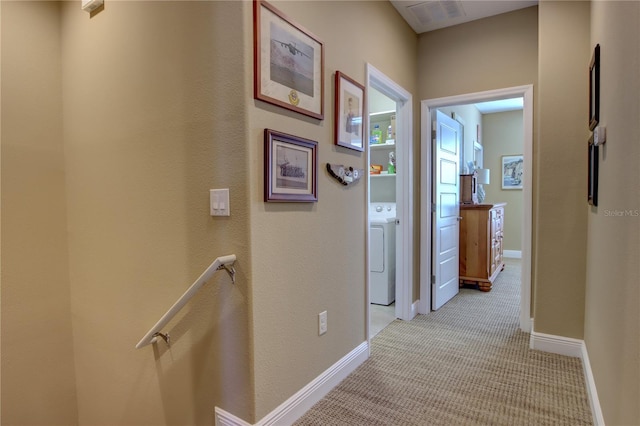 hall with washer / dryer, light carpet, visible vents, and baseboards