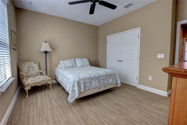 bedroom featuring a closet, visible vents, light carpet, ceiling fan, and baseboards