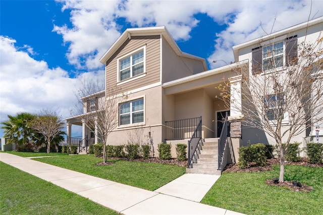 view of front of property featuring a front lawn and stucco siding