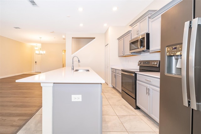 kitchen with visible vents, appliances with stainless steel finishes, light countertops, and a sink