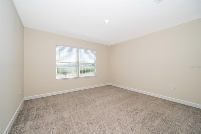 unfurnished room with recessed lighting, light carpet, and baseboards