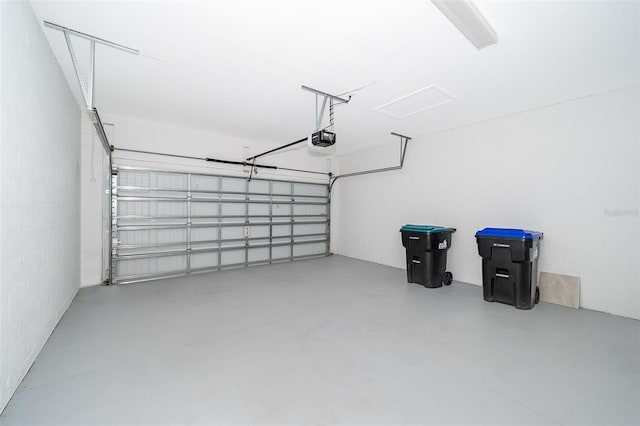 garage featuring concrete block wall and a garage door opener