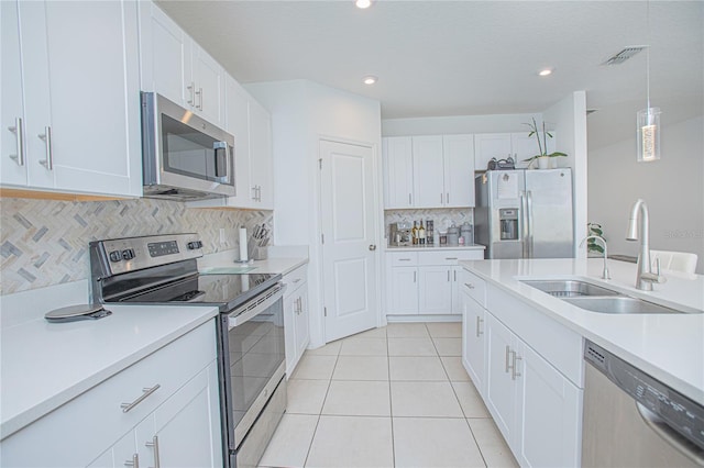 kitchen with visible vents, light countertops, appliances with stainless steel finishes, white cabinetry, and a sink