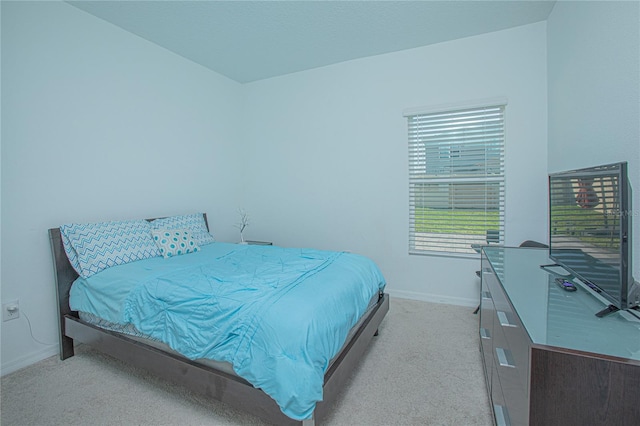 bedroom with baseboards and light colored carpet