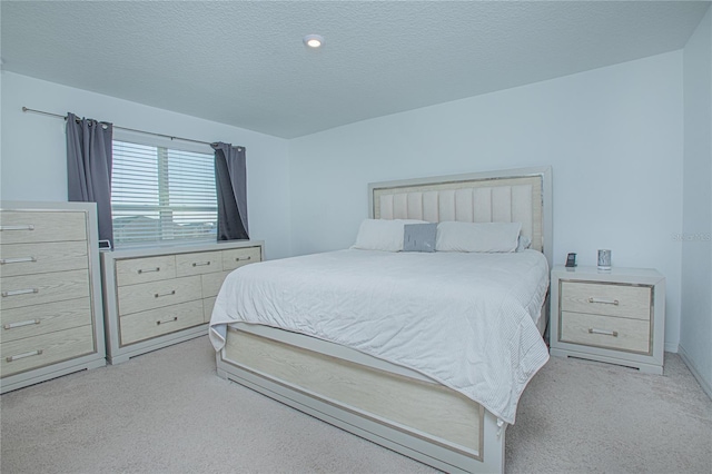 bedroom with a textured ceiling and light carpet