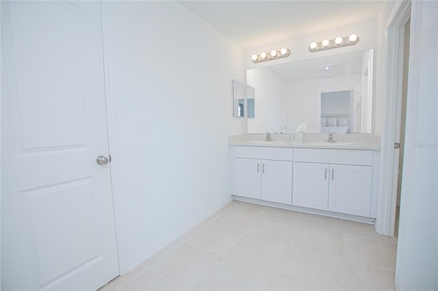 full bath with double vanity, tile patterned flooring, and a sink