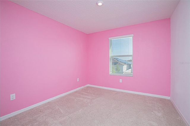 carpeted empty room featuring baseboards and a textured ceiling