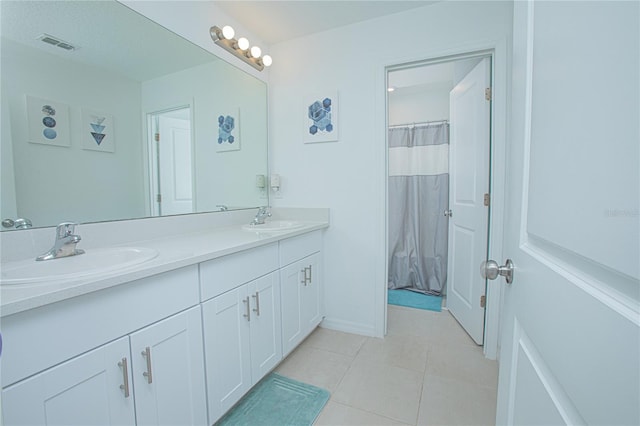 full bathroom featuring tile patterned floors, visible vents, double vanity, and a sink