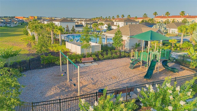 community play area featuring a residential view and fence