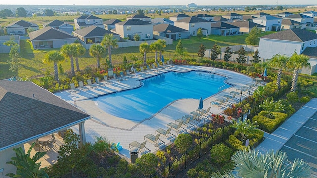 community pool with a patio area, a residential view, and fence