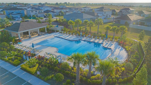 pool featuring a residential view, a patio, and fence