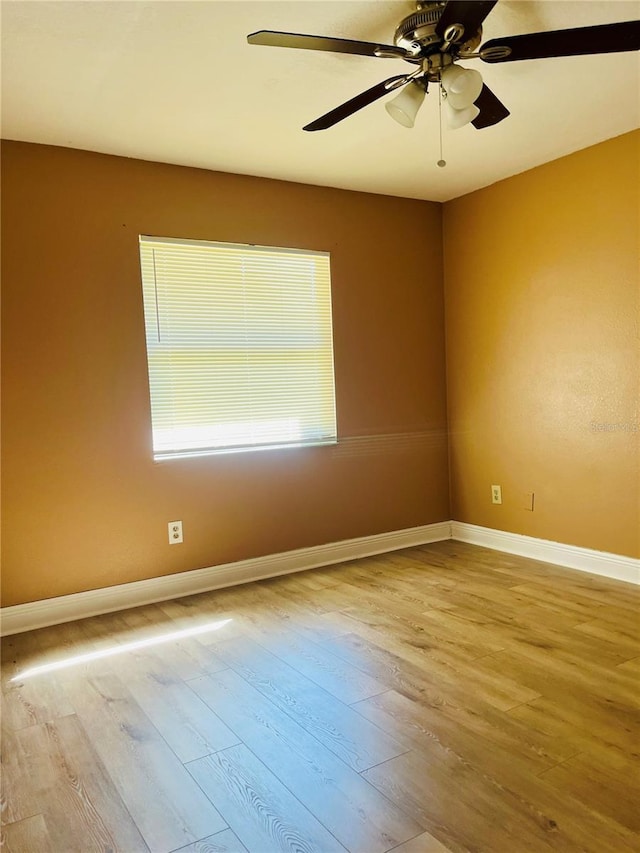 spare room with ceiling fan, baseboards, and wood finished floors