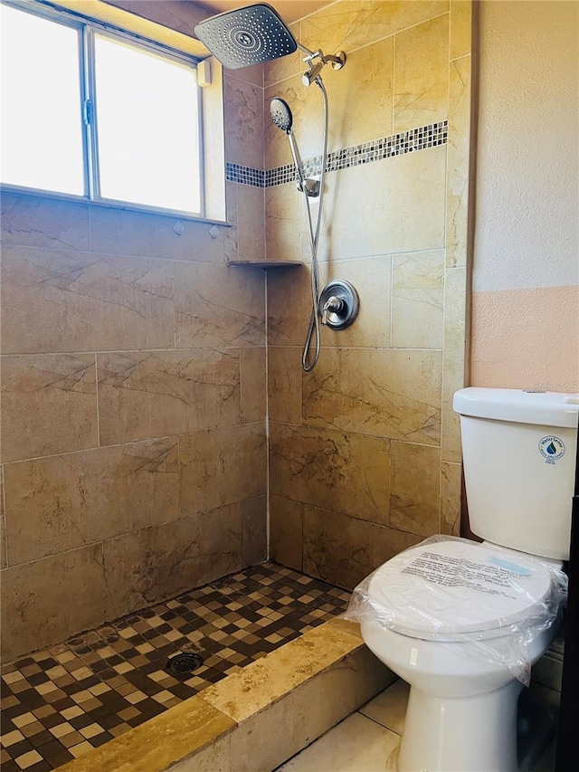 bathroom featuring toilet and a tile shower