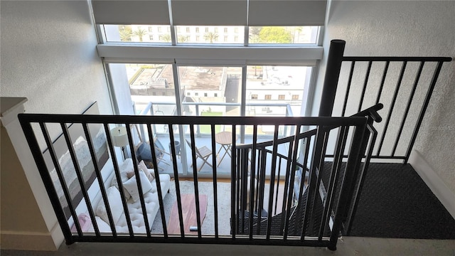 staircase with a towering ceiling and a textured wall