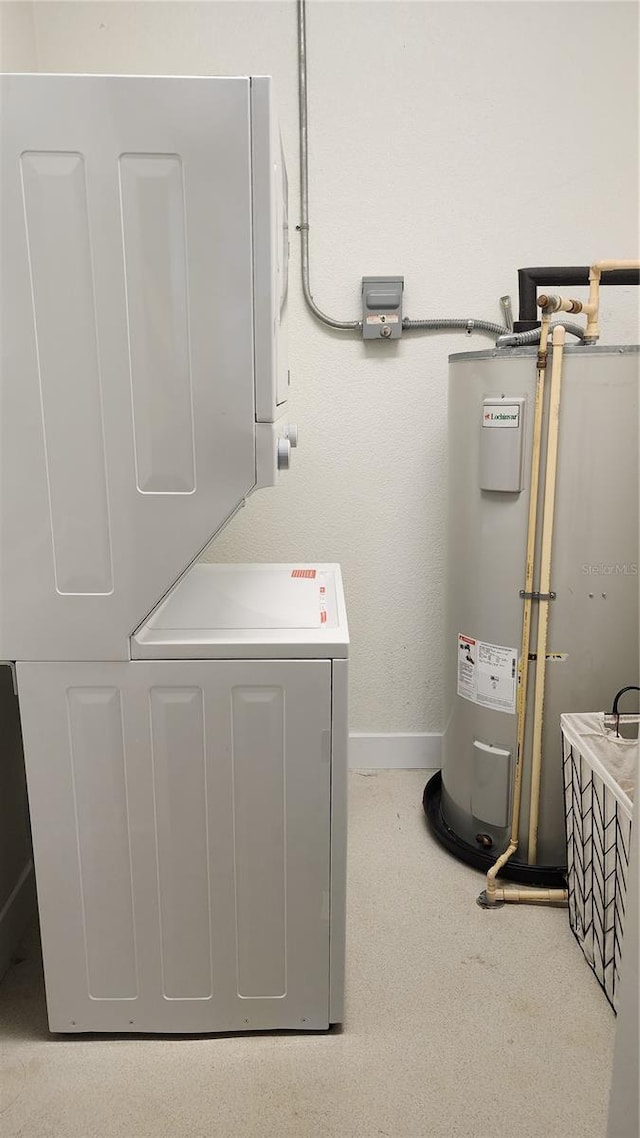 utility room with electric water heater and stacked washer / drying machine