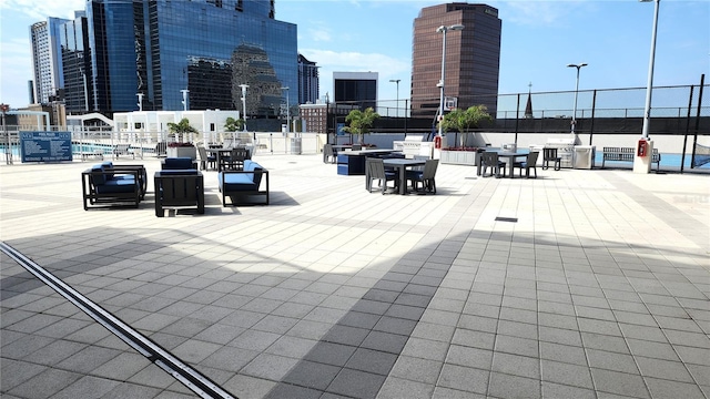 view of patio / terrace featuring a view of city and fence