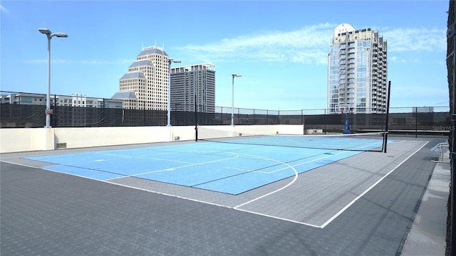 view of sport court with a view of city, community basketball court, and fence