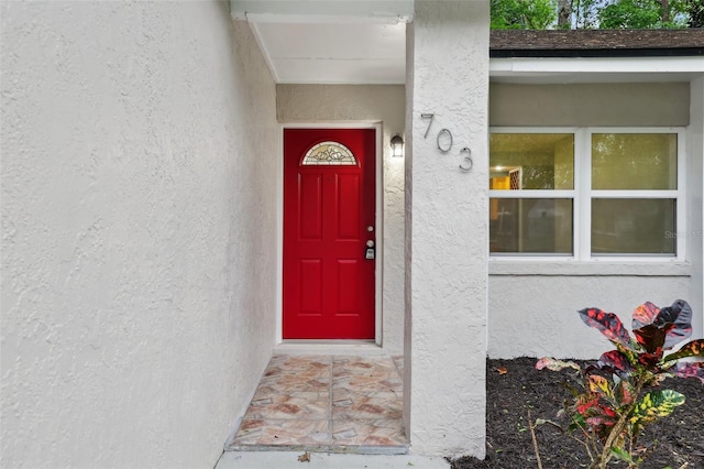 doorway to property featuring stucco siding