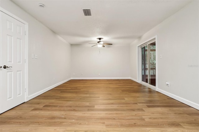 unfurnished room with light wood-style floors, baseboards, visible vents, and a ceiling fan