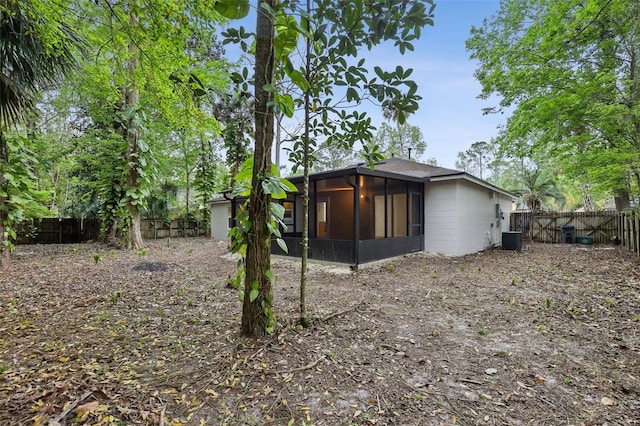 view of side of property featuring a sunroom, a fenced backyard, and central air condition unit