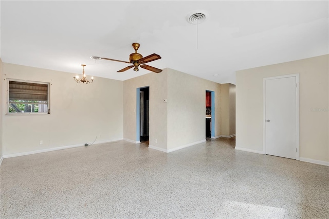 empty room with ceiling fan with notable chandelier, visible vents, baseboards, and speckled floor