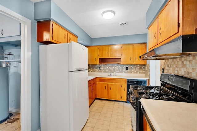 kitchen with light countertops, black range with gas stovetop, freestanding refrigerator, a sink, and under cabinet range hood