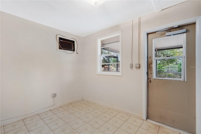 doorway with a wall unit AC and baseboards